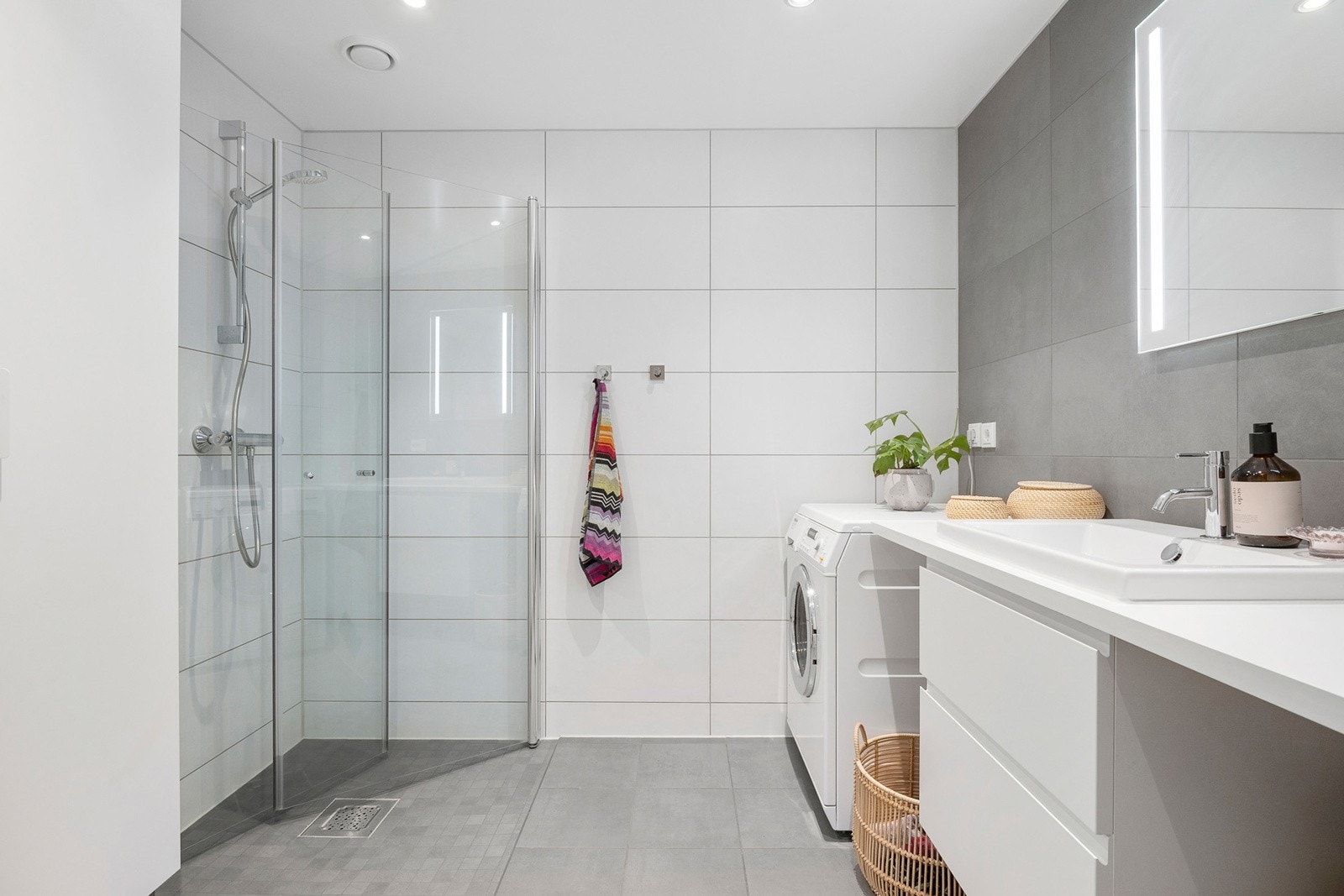 Flott flislagt baderom med downlights, varmekabler og opplegg til vaskemaskin Galleribilde