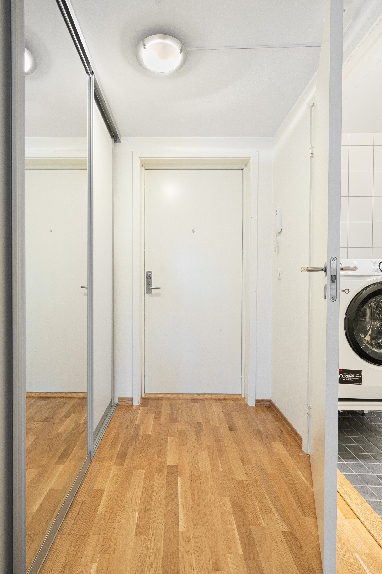 Lys og innbydende entré med plass til yttertøy i skyvedørsgarderobe. Galleribilde