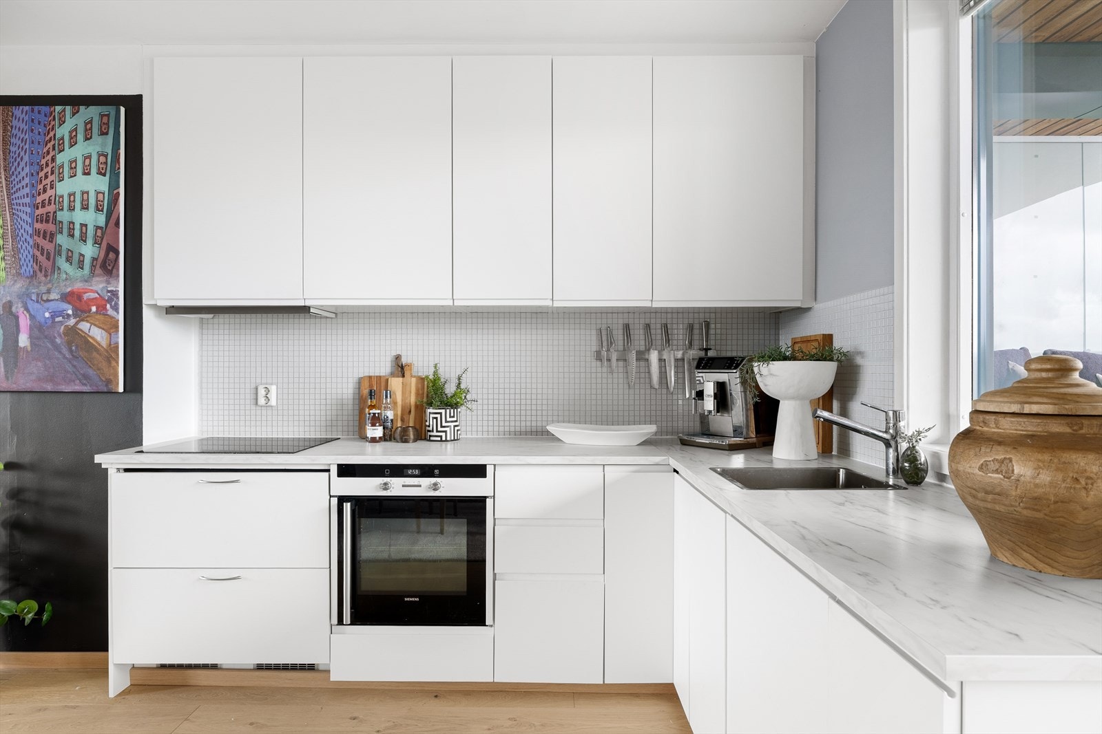 Pen og slett kjøkkeninnredning med laminert benkeplate og integrerte hvitevarer. Galleribilde