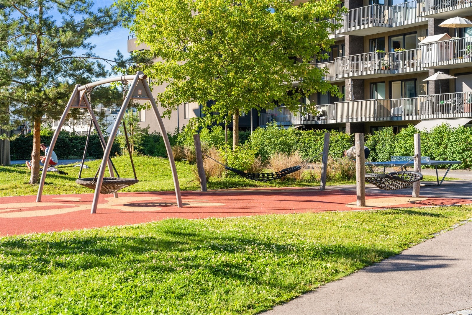 Tomten er parkmessig opparbeidet med asfalterte internveier, steinsatte arealer, blomsterbed, variert beplantning, lekeapparater og sittegrupper. Galleribilde