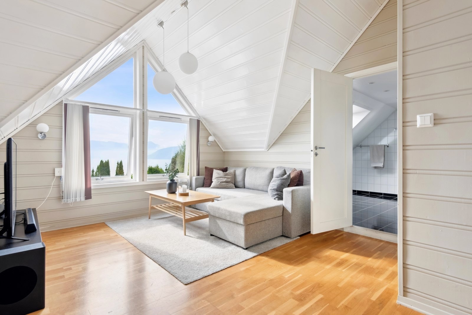 Oppe i 2. etasje blir møtes man av en fin tv-stue med praktfull utsikt over fjorden Galleribilde