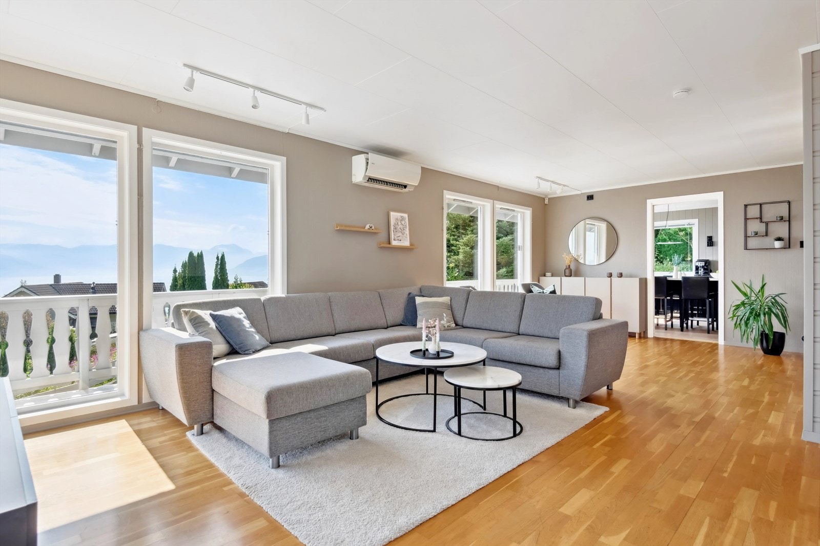 Oppe i 1. etasje er det en romslig stue med høye vinduer Galleribilde