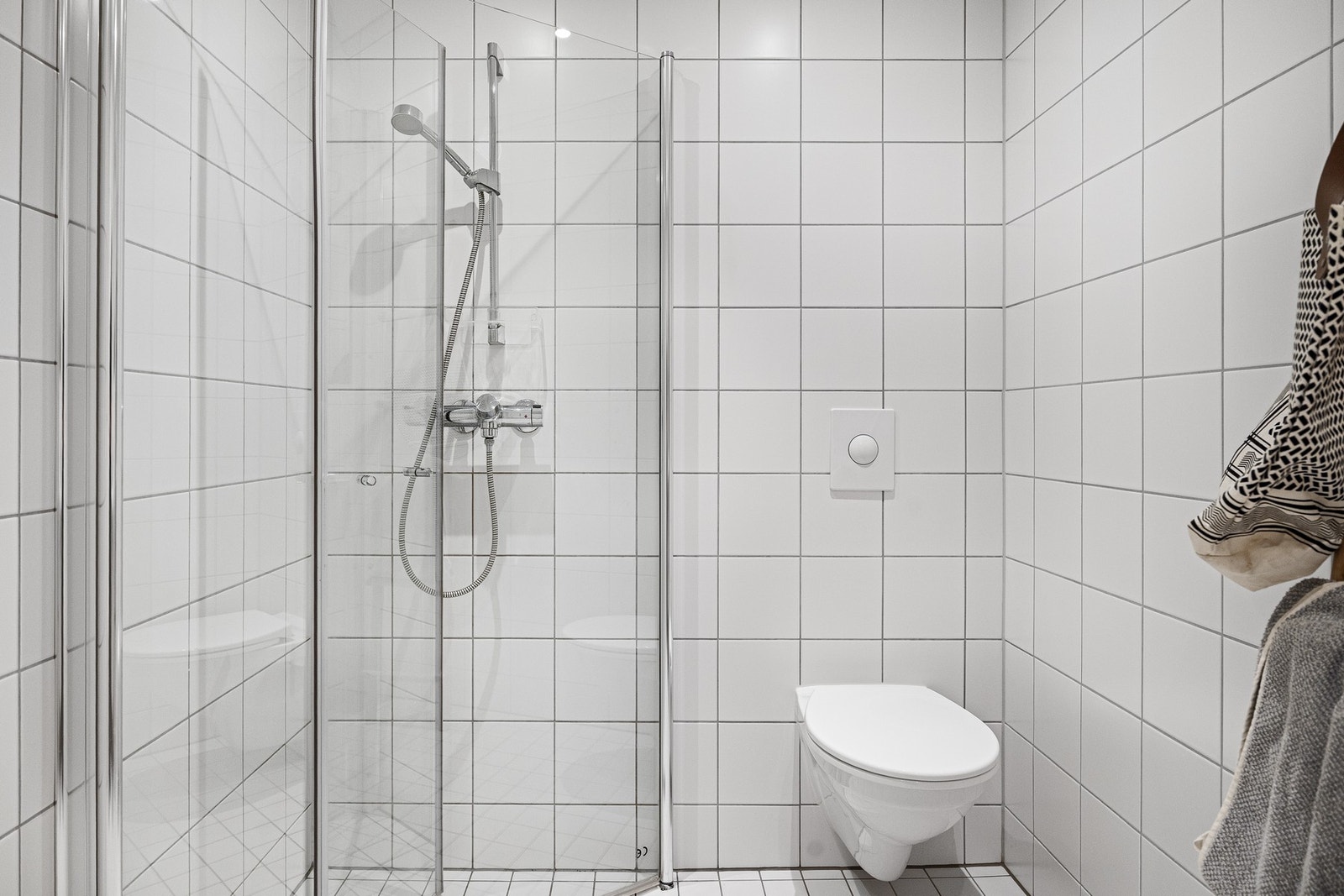 Romslig dusjnisje bak innfellbare dusjdører i glass. Galleribilde