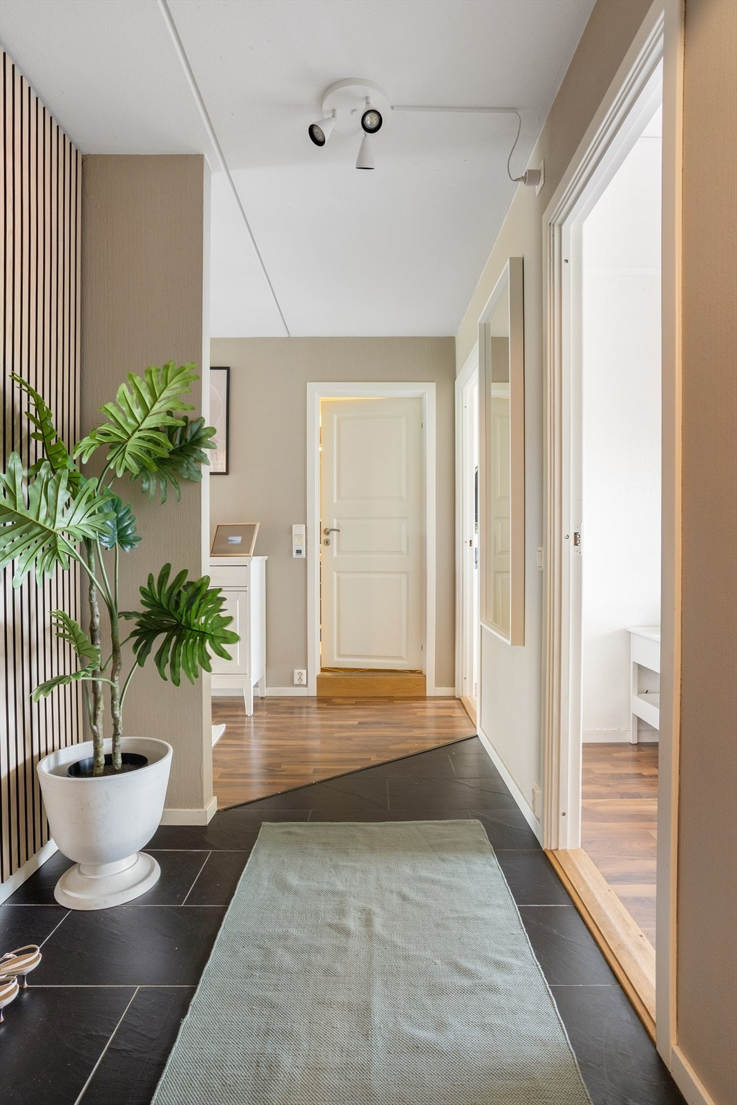 Hyggelig entrè med flott spilevegg, samt plass til oppbevaring av sko og yttertøy Galleribilde