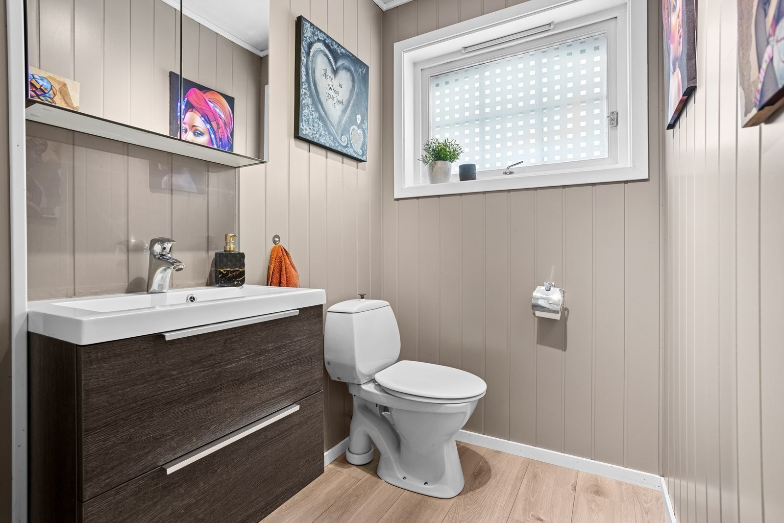 Boligen har et separat toalettrom med laminatgulv og malte overflater. Rommet er innredet med et toalett, vask med underskap og speilskap. Galleribilde