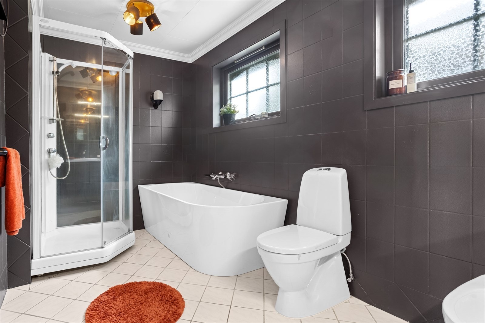 Badet er innredet med et dusjkabinett, badekar, toalett, bidé, moderne innredning med skuffeseksjon og to servanter, høyskap og speil overskap. Galleribilde