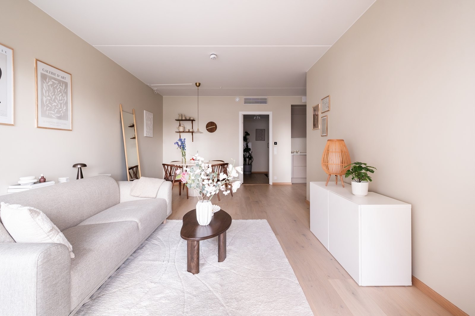 Lys og trivelig stue med åpen kjøkkenløsning - smart utformet slik at sonene føles både sosiale og skjermet Galleribilde