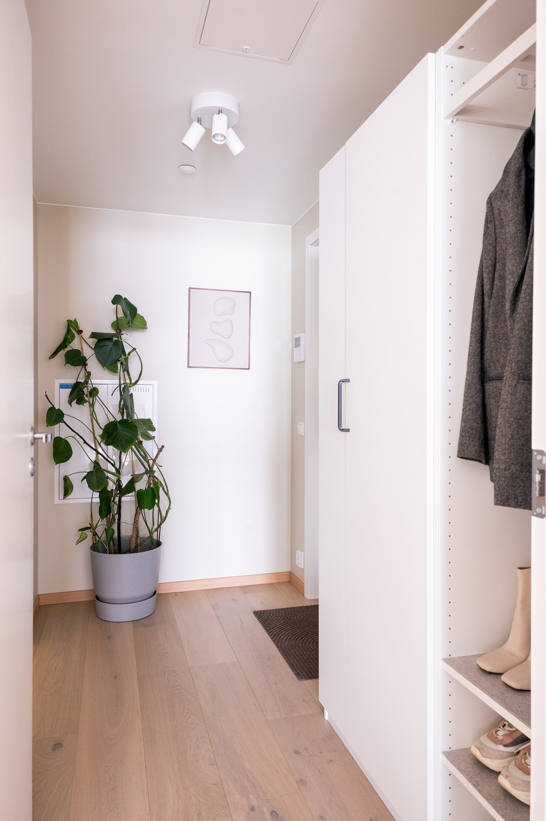 Entréen er lys og innbydende med downlights, og har garderobeskap med hvite, glatte fronter som gir god lagringsplass Galleribilde