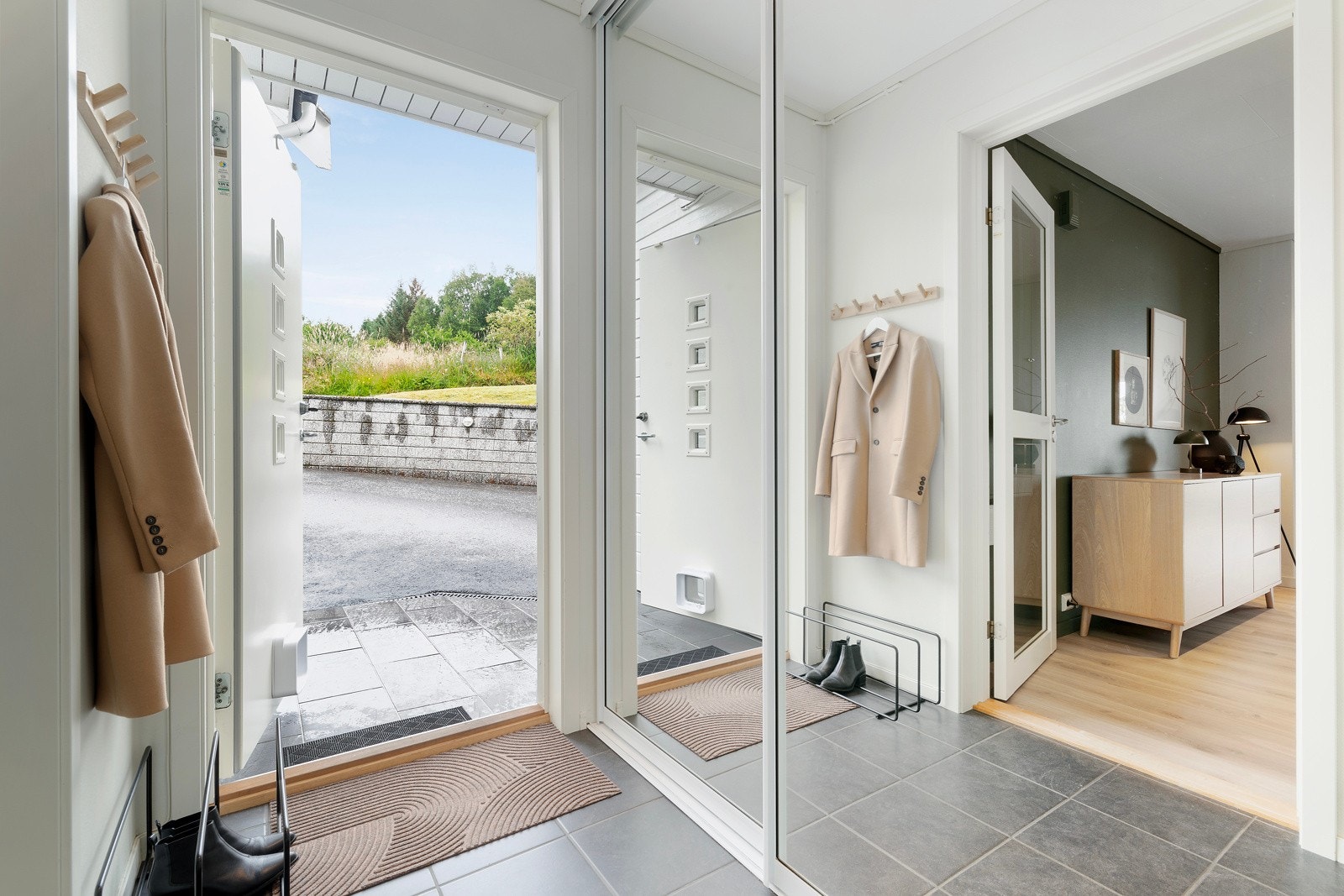 Her kommer vi inn i en flislagt entré med en romslig skyvedørsgarderobe. Galleribilde