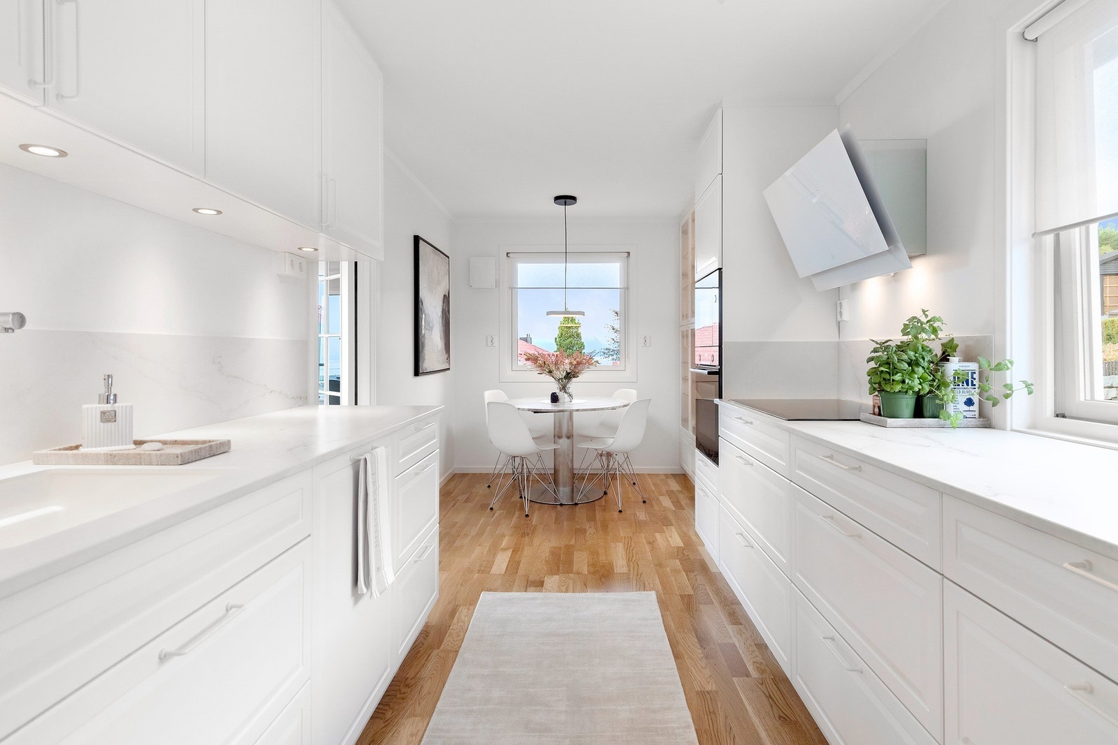 Innholdsrikt kjøkken med dekton benkeplate, integrert stekeovn, koketopp, oppvaskmaskin og kjøleskap med fryser Galleribilde