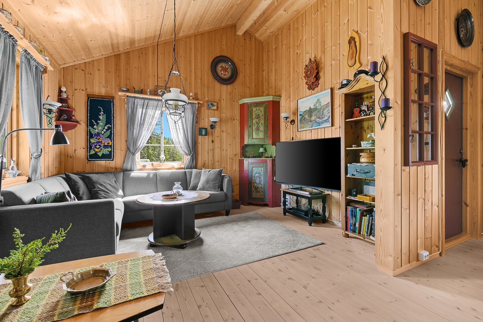 Stuen er et koselig rom med like, tradisjonelle overflater som i resten av hytta. Galleribilde