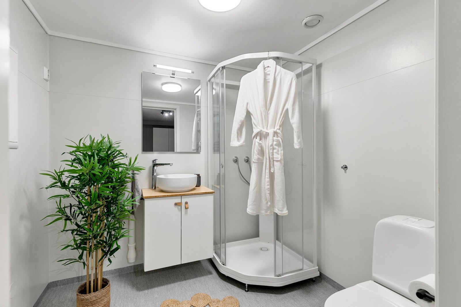 Fint bad med dusjkabinett, servant med skap, opplegg for vaskemaskin og toalett. Galleribilde