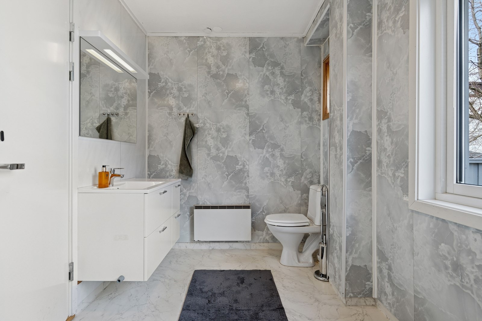 Bad/vaskerom med vinylbelegg på gulv og vegger med baderomsplater Galleribilde