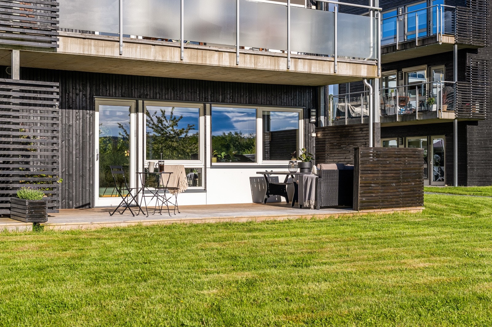 Grøntområdet utenfor terrassen oppleves som en forlengelse av uteplassen, og sørger for minimalt med innsyn inn i leiligheten. Galleribilde