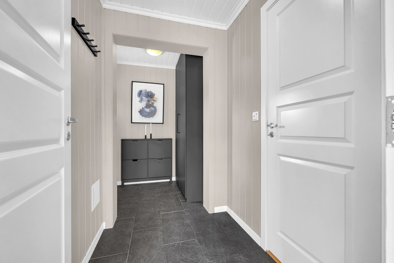 Entréen ønsker deg velkommen med flislagt gulv, gulvvarme og god plass til sko og yttertøy. Galleribilde