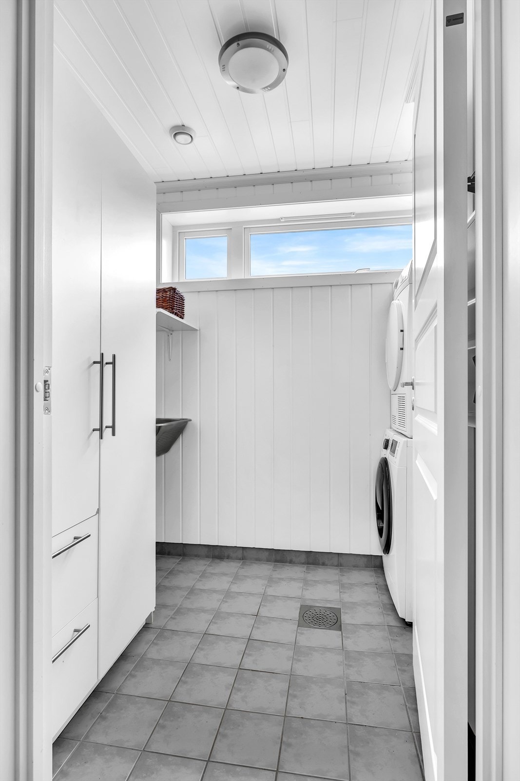 Separat vaskerom med flislagt gulv og panel på veggene. Her er det god plass til både vaskemaskin, tørketrommel og utslagsvask. Galleribilde