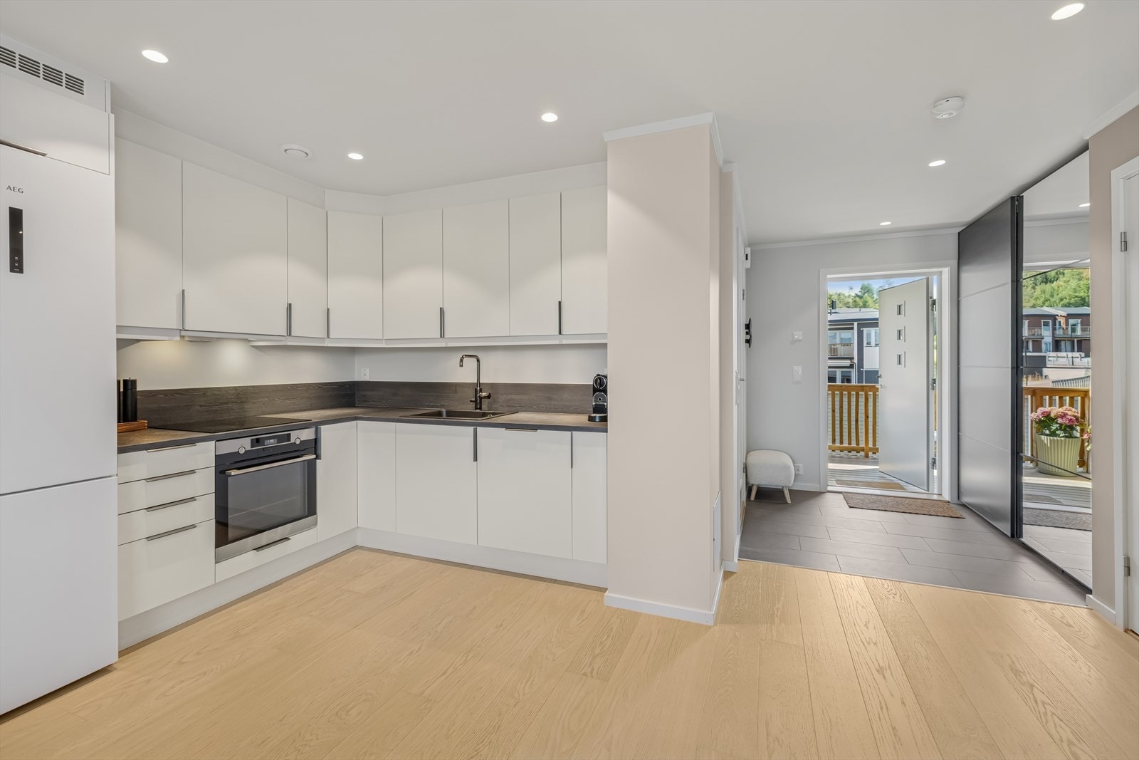 Delikat kjøkken med glatte fronter og laminat benkeplate med en oppvaskkum. Galleribilde