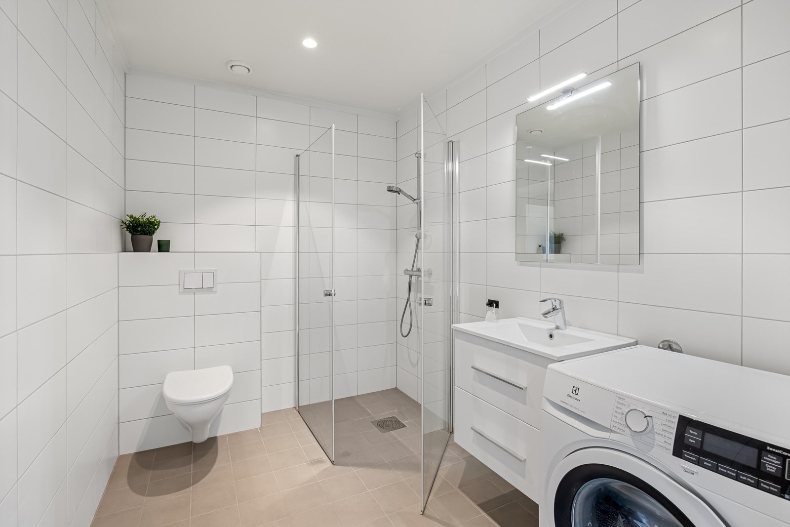 Pent bad med fliser på vegger og gulv med gulvvarme. Galleribilde