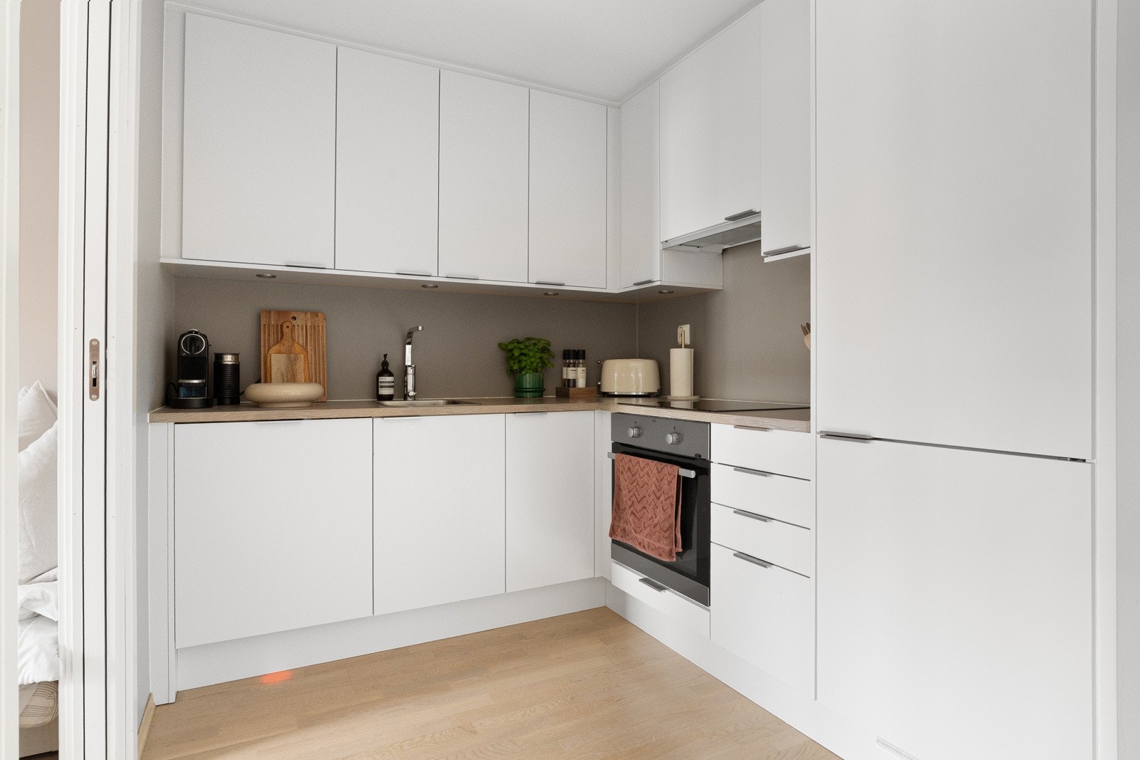 Kjøkkenet har opplegg for platetopp, oppvaskmaskin, stekeovn og kombi kjøl/frys. Integrerte hvitevarer medfølger leiligheten. Galleribilde