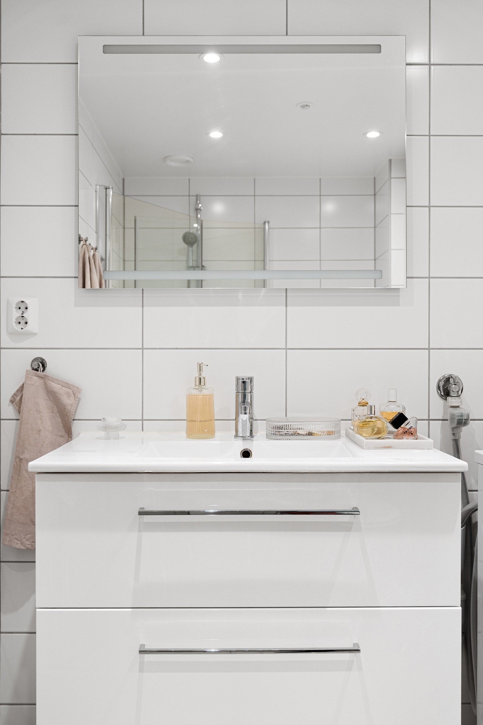 Videre er det speil med integrert belysning på vegg over servant, dusjhjørne og toalett. Det er opplegg for vaskemaskin. Galleribilde