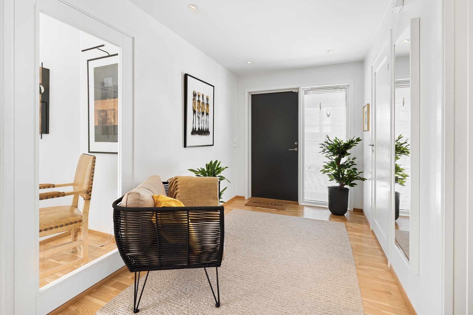 Entreen innredet med parkettgulv, downlights og hvitmalte veggflater. Tilknyttet entreen har boligen et praktisk gjestetoalett, og bak en skyvedør finner man et walk-in closet med skuffer, hyller og klesoppheng. Inn til stuen har entreen en glassdør. Galleribilde