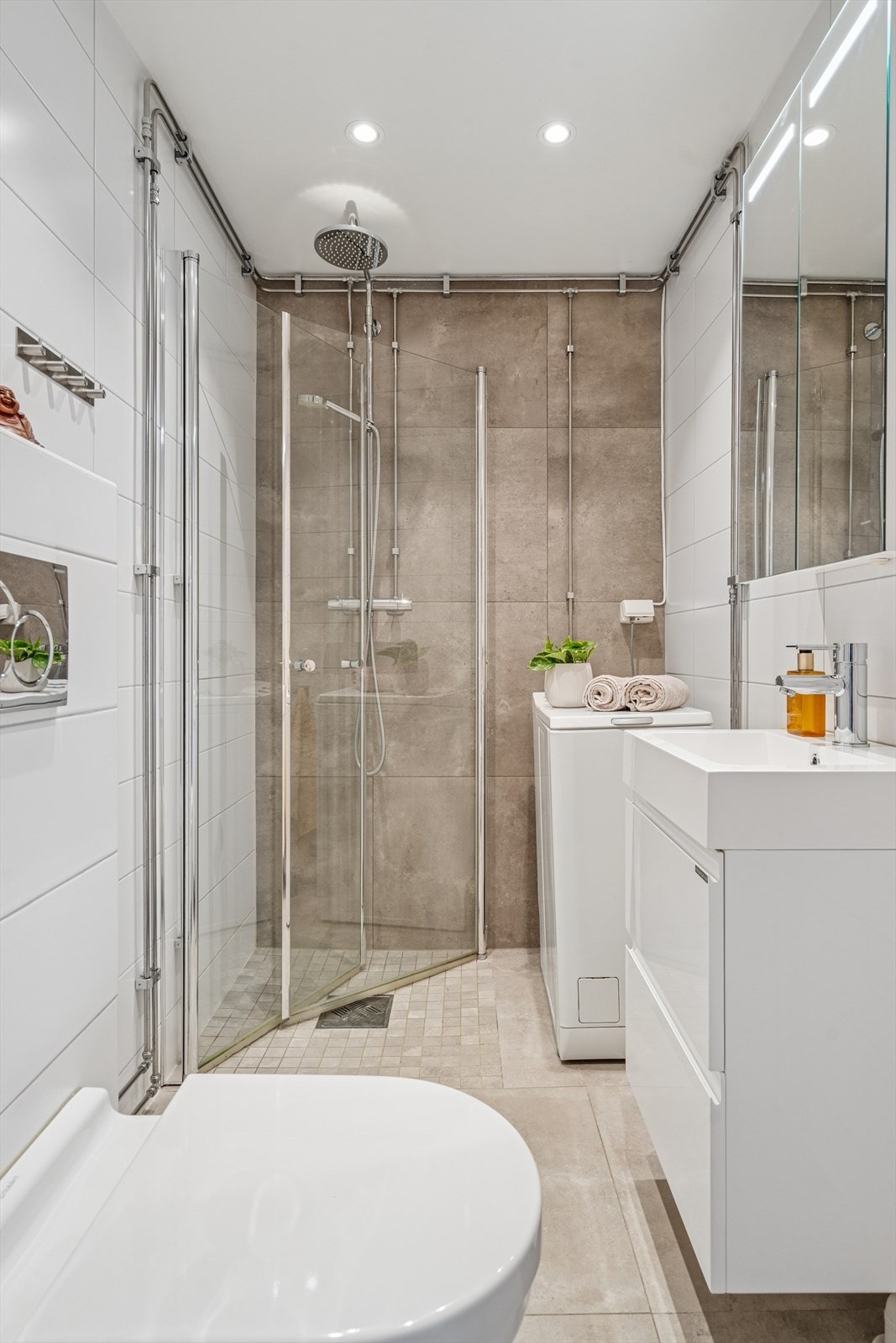 Rommet er utstyrt med vegghengt toalett, dusjhjørne m/innfellbare glassdører, baderomsinnredning og opplegg for vaskemaskin Galleribilde