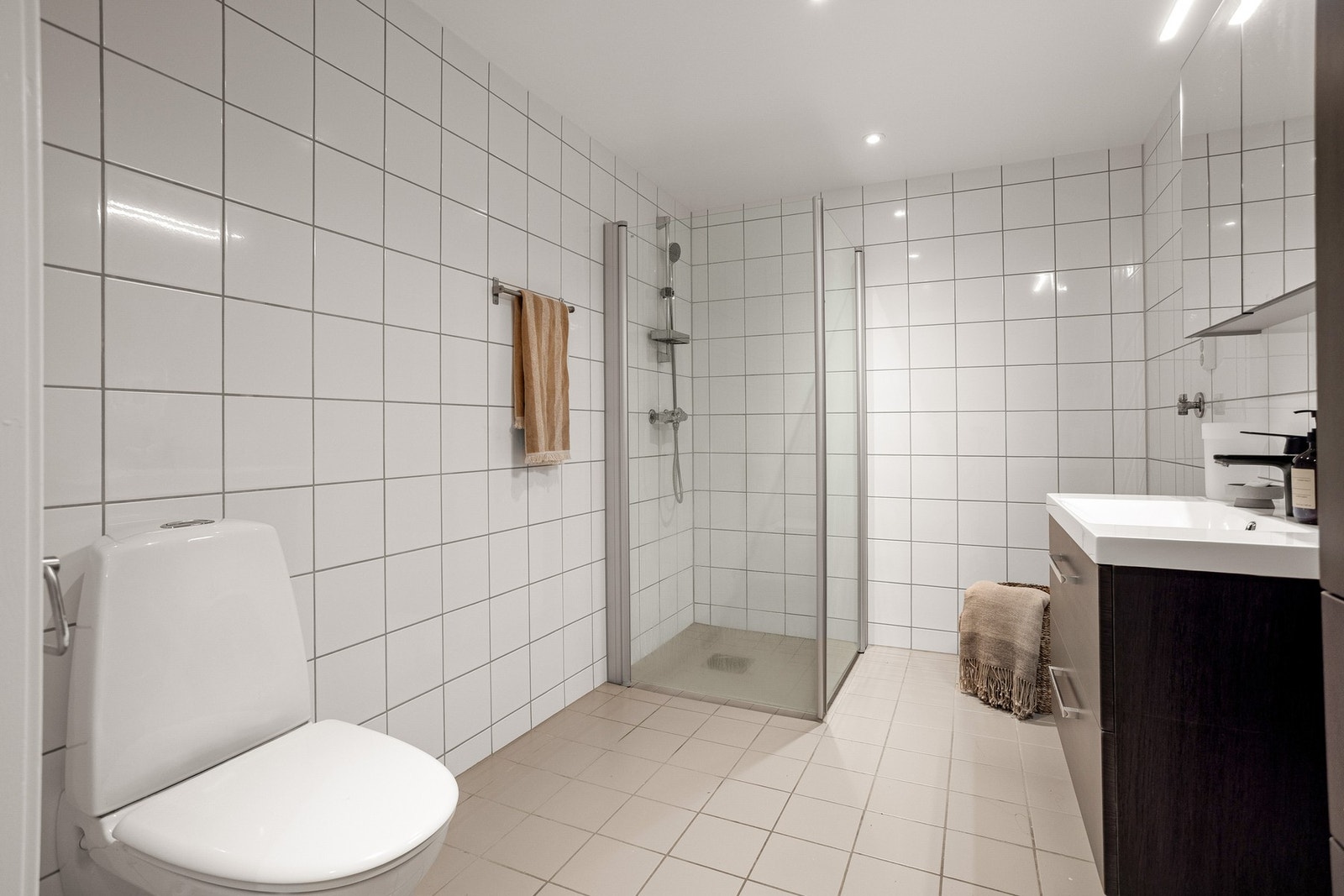 Stilrent bad med moderne oppgraderinger fra 2022. Badet har flislagt gulv med komfortabel gulvvarme, samt flislagte vegger som gir et helhetlig og pent uttrykk. Galleribilde