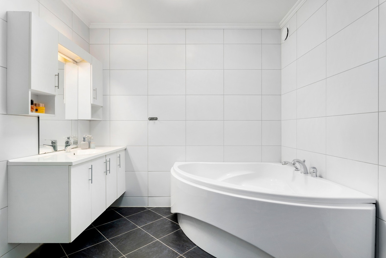 I tillegg til dusjssone er her herlig hjørnebadekar, legg også merke til servantinnredningen med hele 4 dører, pluss overskap. Galleribilde