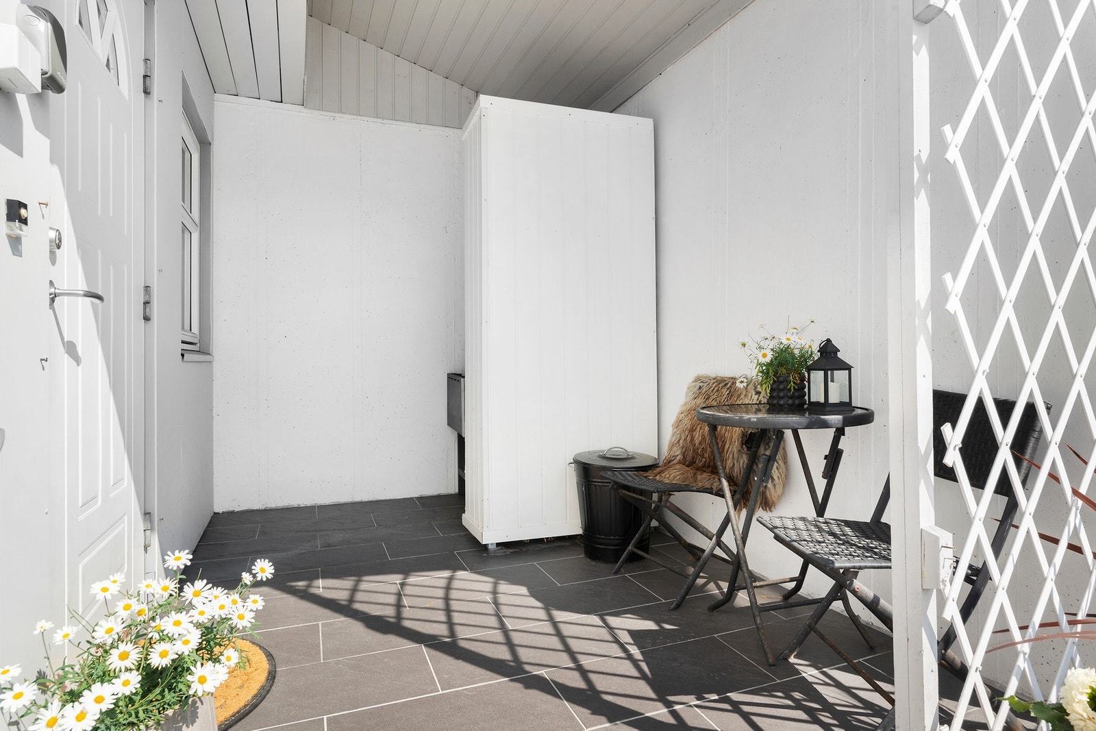 Koselig inngangsparti som er overbygd, flislagt dekke og du har nøkkelboks med kode for oppbevaring av nøkkel. Galleribilde