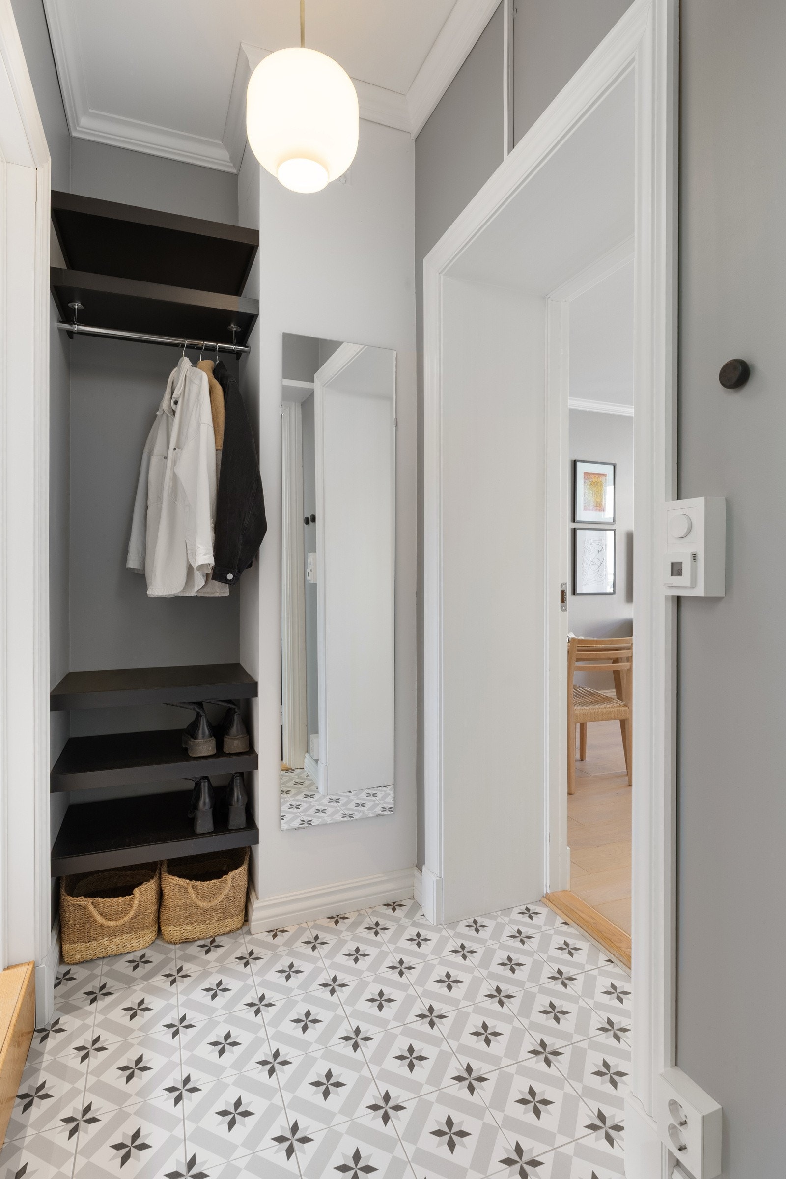 Her er det fliser på gulv med gulvvarme og slette vegger i en myk fargepalett. Det er god plass til oppbevaring av sko og yttertøy Galleribilde