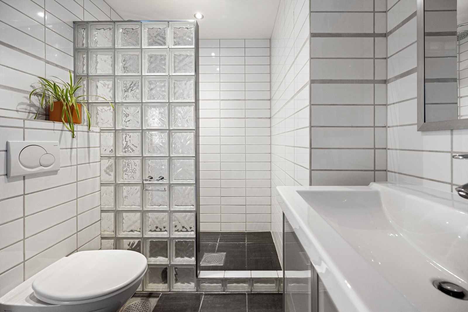 Romslig dusjnisje og vegghengt toalett. Galleribilde