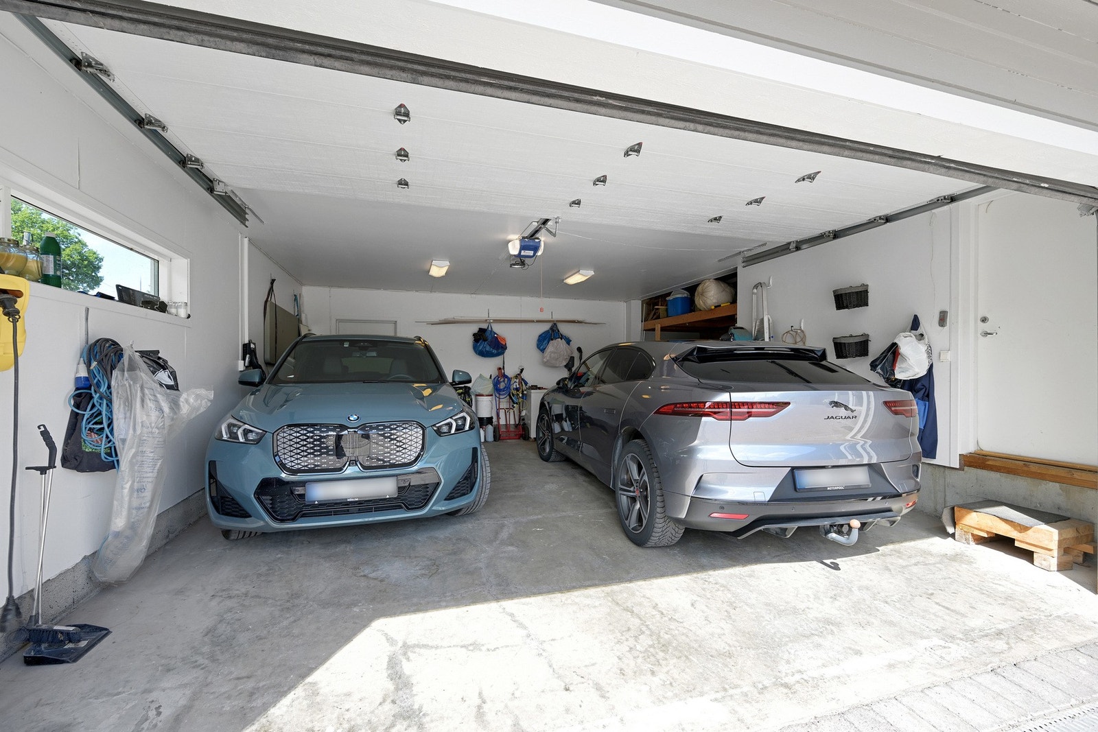 Stor garasje med leddport og to ladestasjoner - tørrskodd adkomst videre til vindfanget Galleribilde