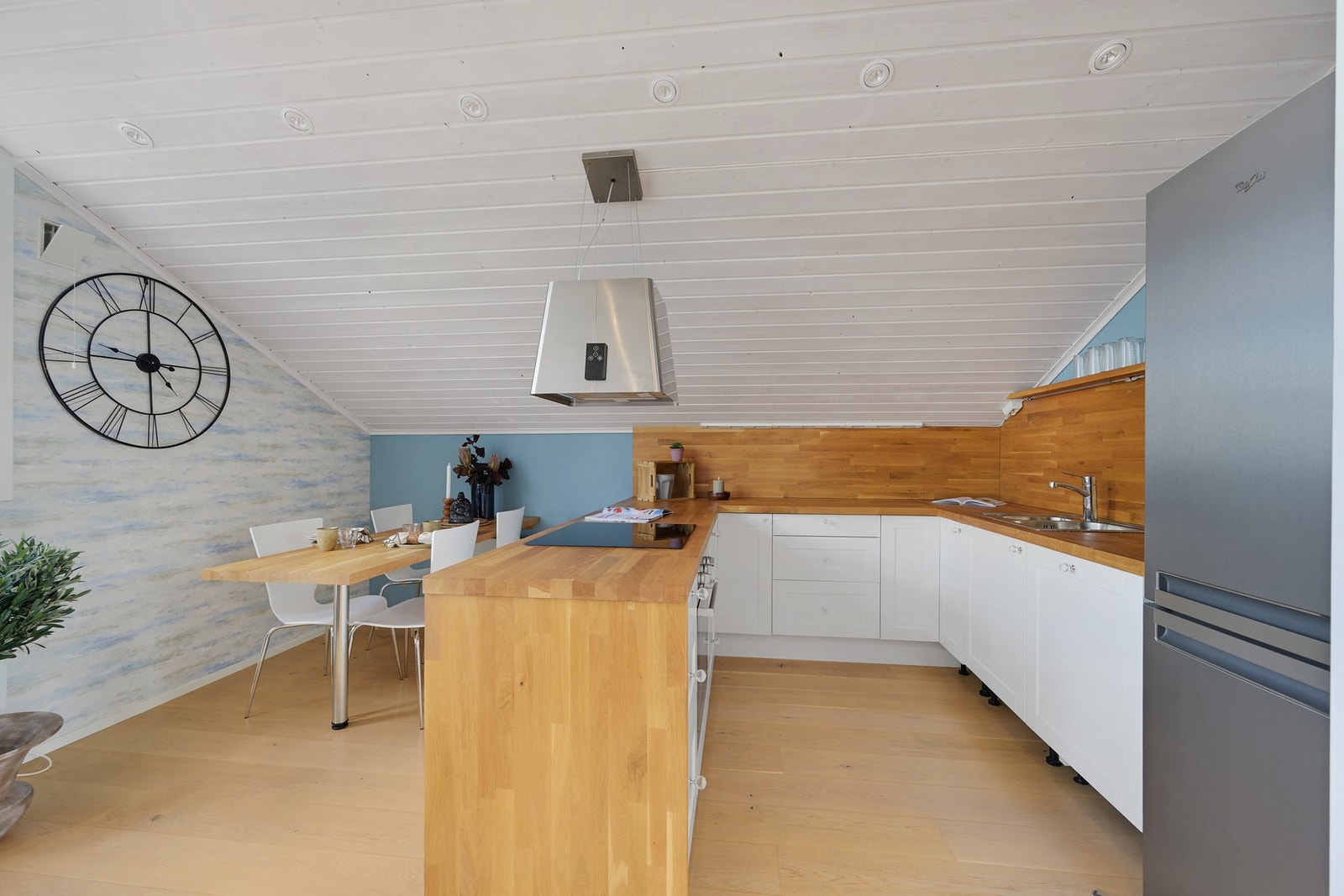 Lys innredning med heltre benkeplater og spesial tilpasset kjøkkenbord Galleribilde