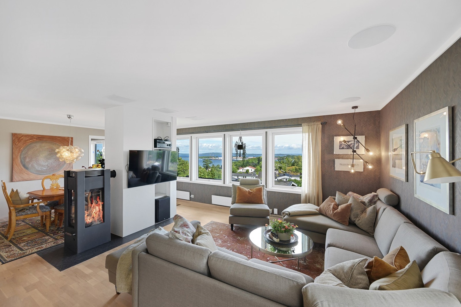 Romslig og oppusset stue med store vindusflater mot fjorden Galleribilde