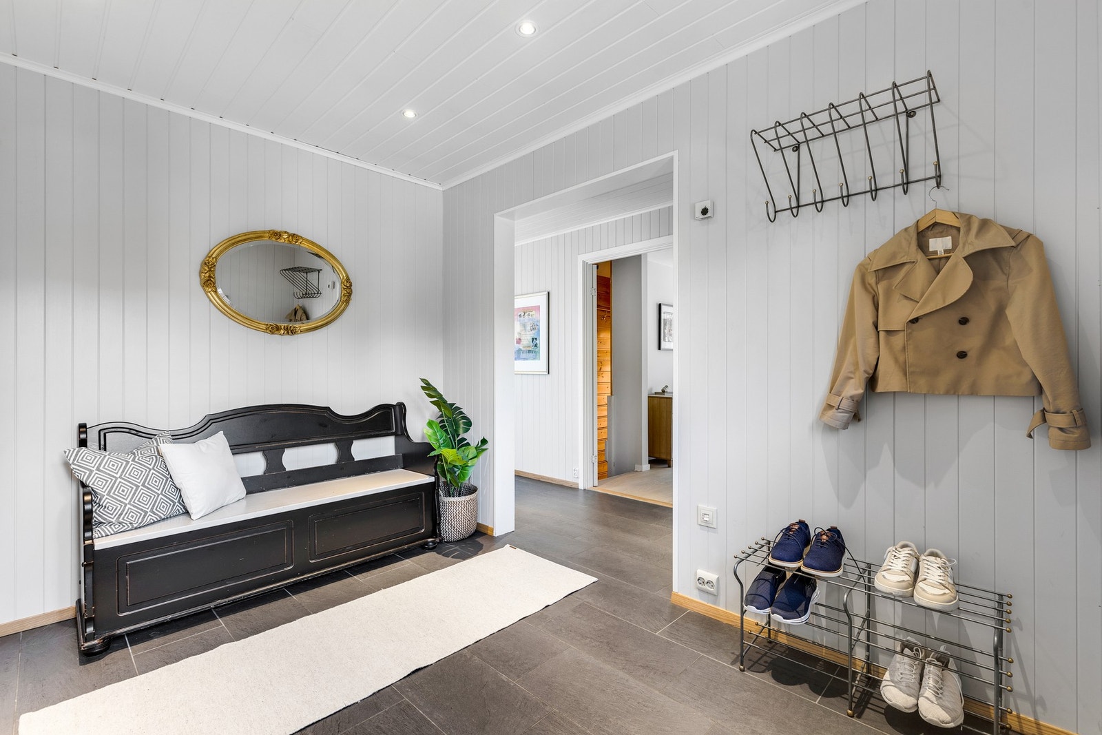 Lys og fin entré med enkel klesoppheng og oppbevaring i skyvedørsgarderobe. Galleribilde