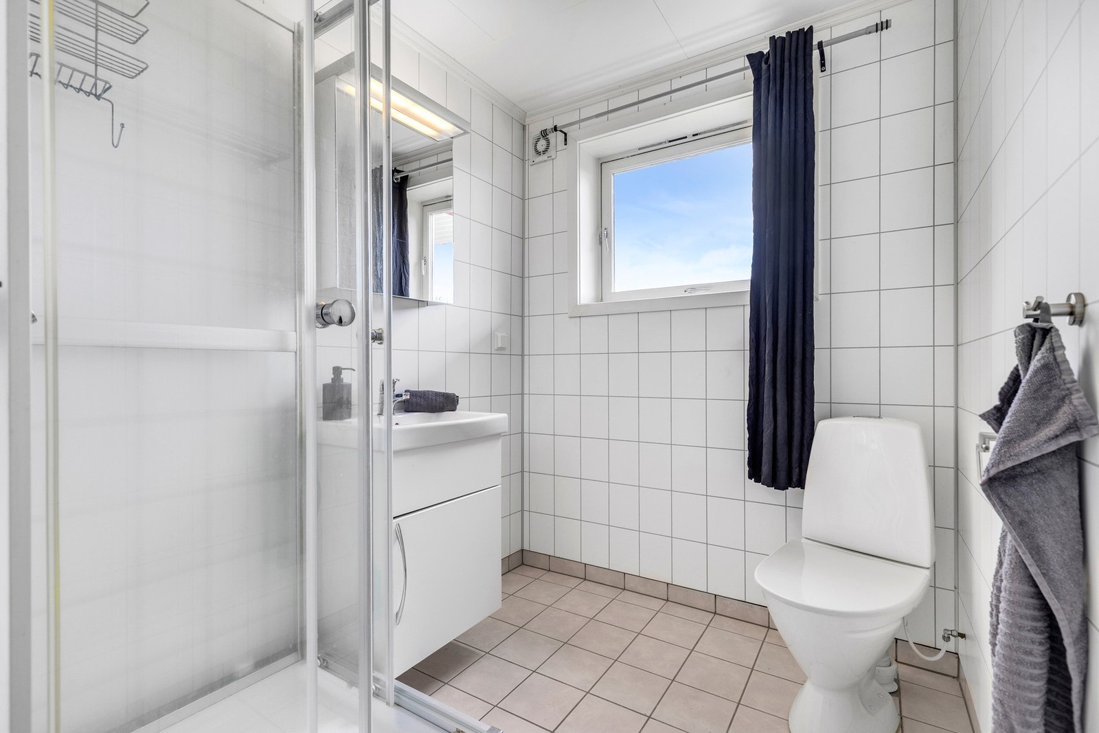 Flislagt bad i sokkelleiligheten på 6 kvm med varmekabler og opplegg for vaskemaskin. Galleribilde