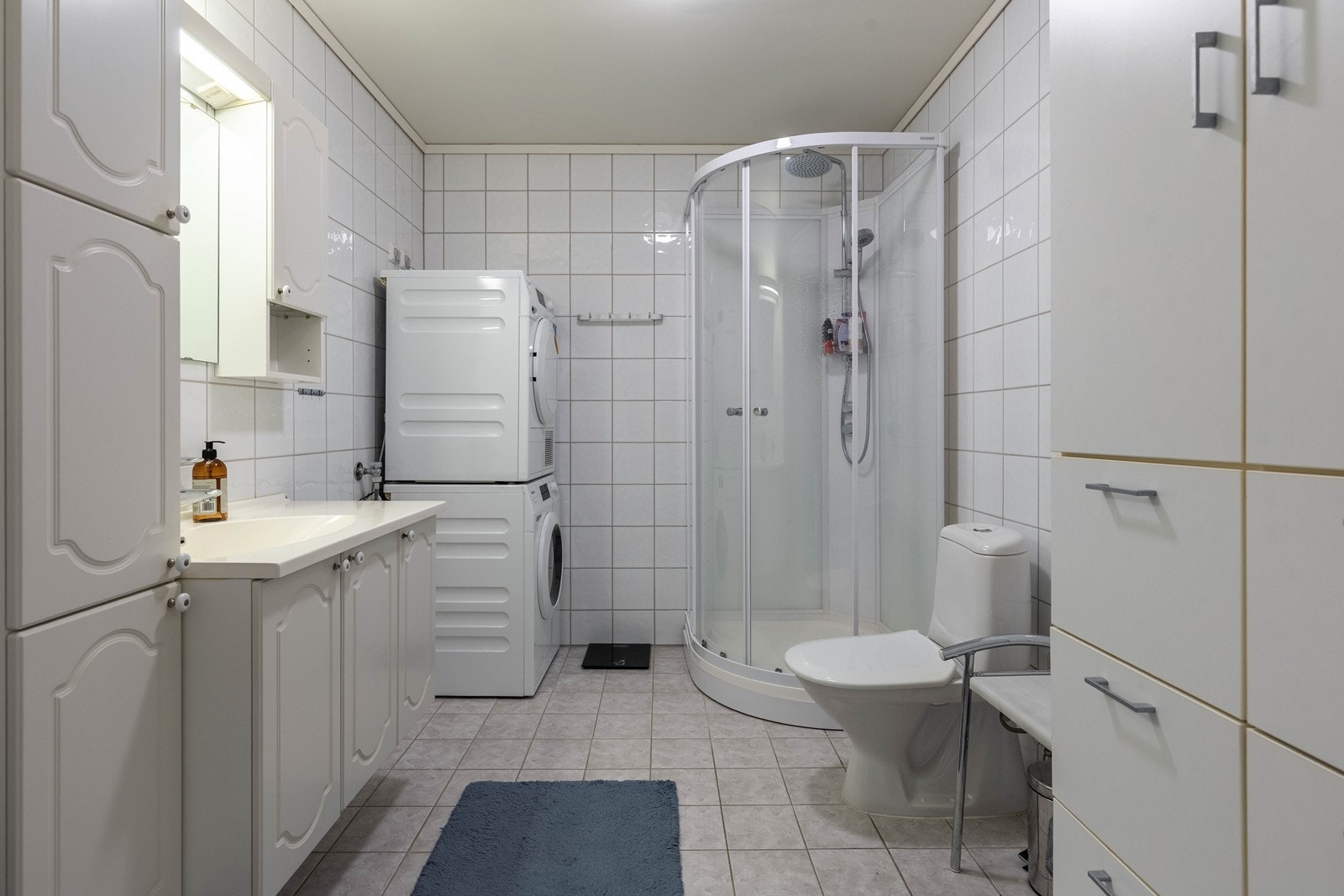 Flislagt bad/ vaskerom med god plass til oppbevaringsmøblement Galleribilde