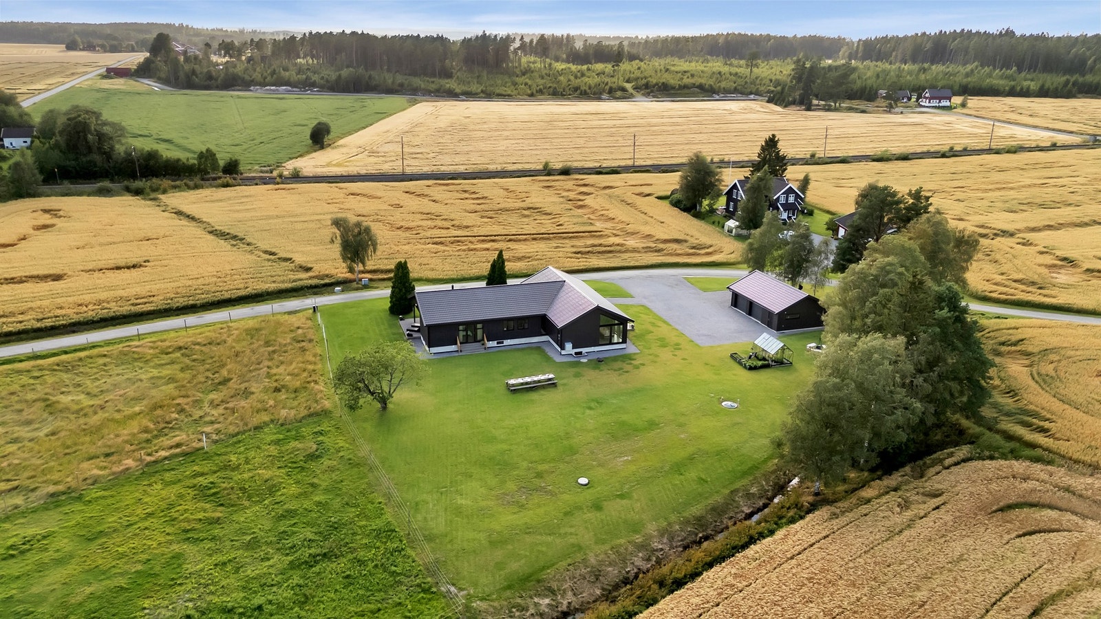 Eiendommen har stor gressplen for lek og moro til familien Galleribilde