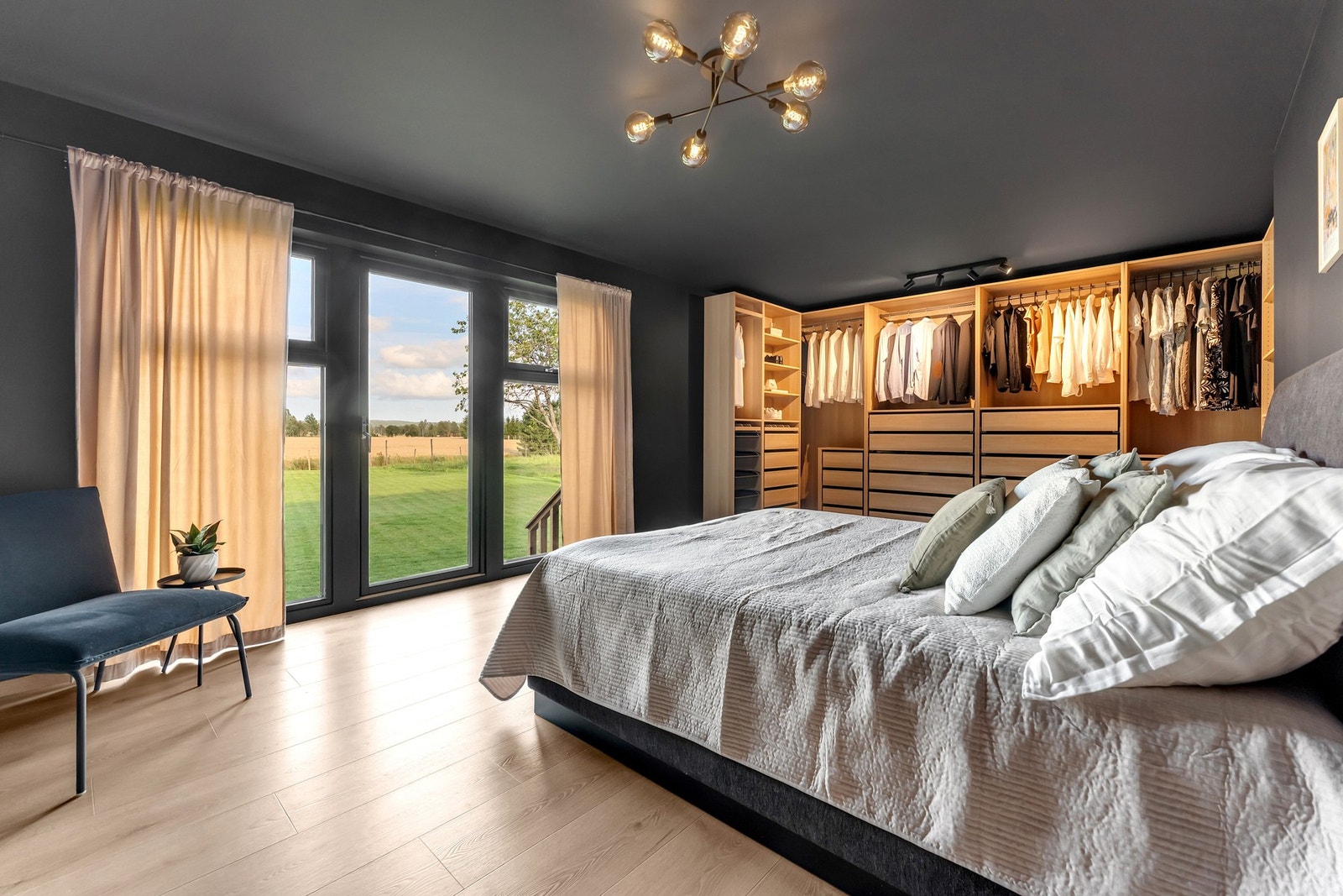 Lekkert og moderne hovedsoverom med romslig utforming. Her våkner man til herlig utsikt over hage og åkerlandskap Galleribilde