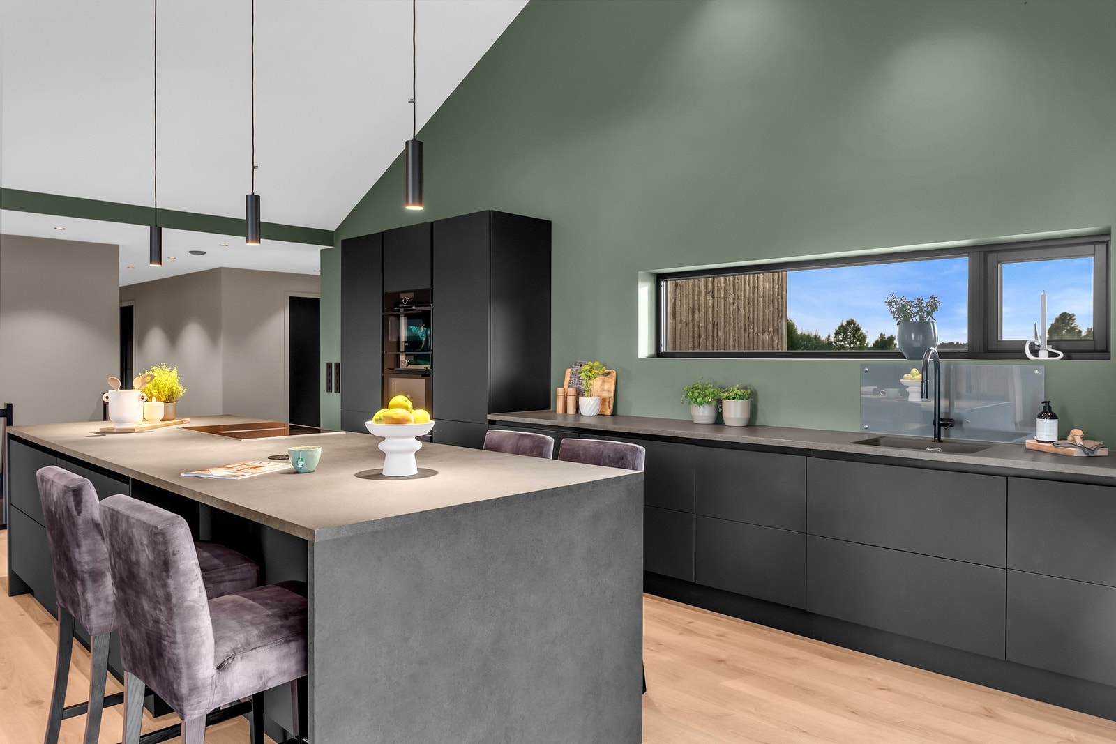 Kjøkkenet har en stor kjøkkenøy for ekstra oppbevaring og som er et naturlig skille mot stuen Galleribilde