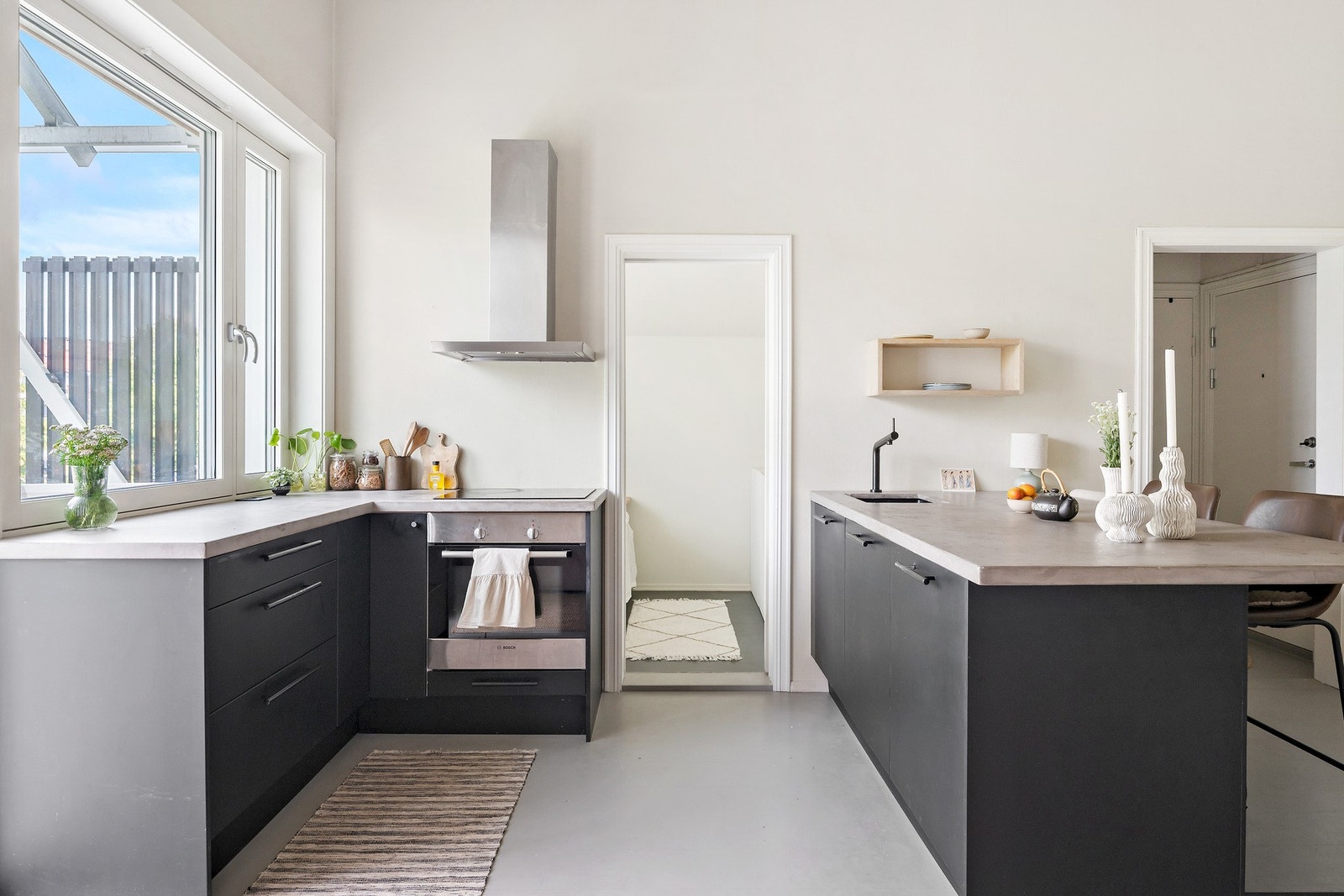 Lekker kjøkkeninnredning med slette fronter, benkeplate av betong og integrerte hvitevarer Galleribilde