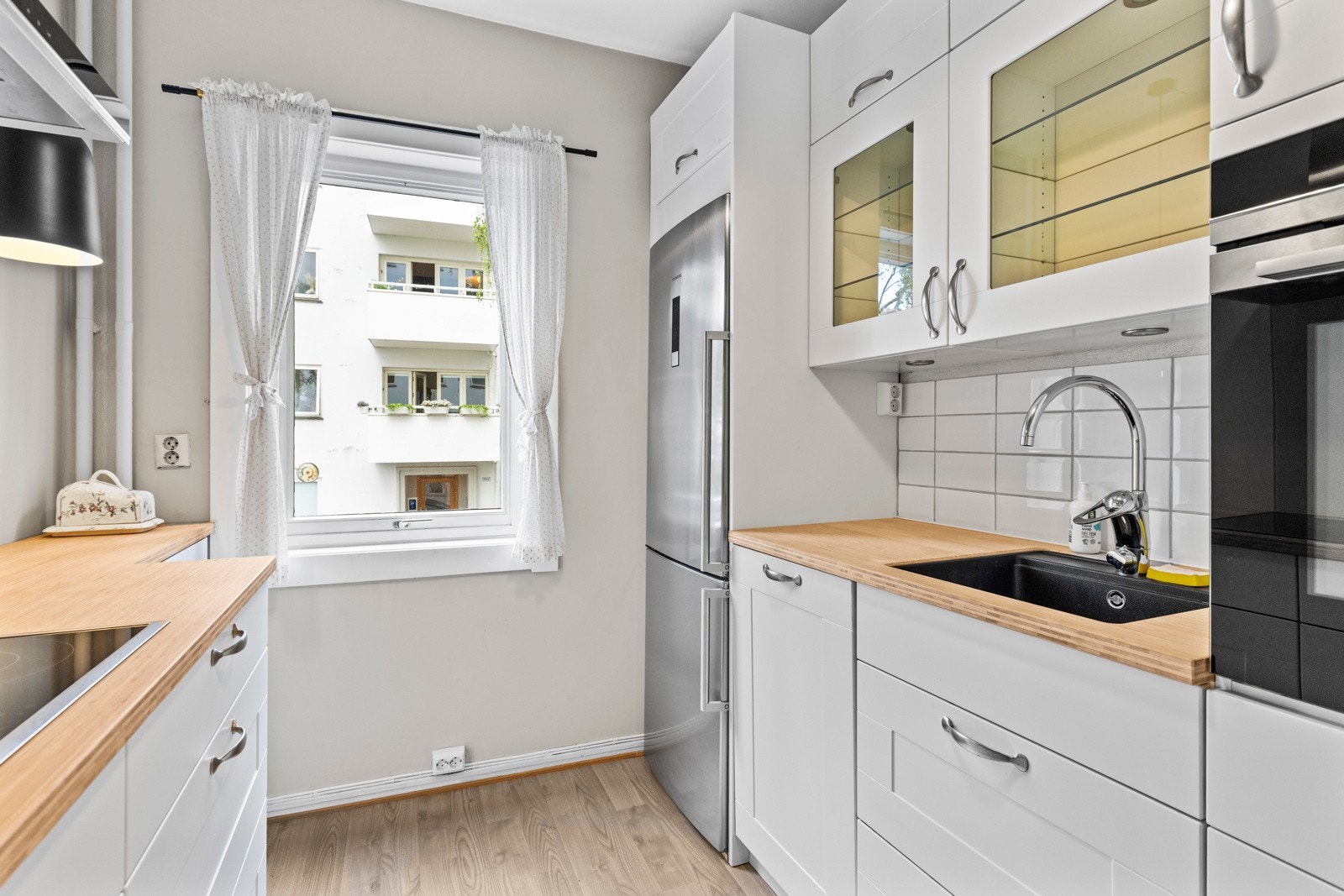 Benkeplate av bambus og med nedfelt oppvaskkum i sort kompositt og ett-greps blandebatteri. Galleribilde