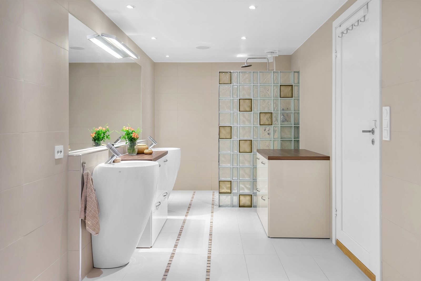 Flislagt bad med dobbel vask og stor dusj bak dusjvegg i glass. Galleribilde