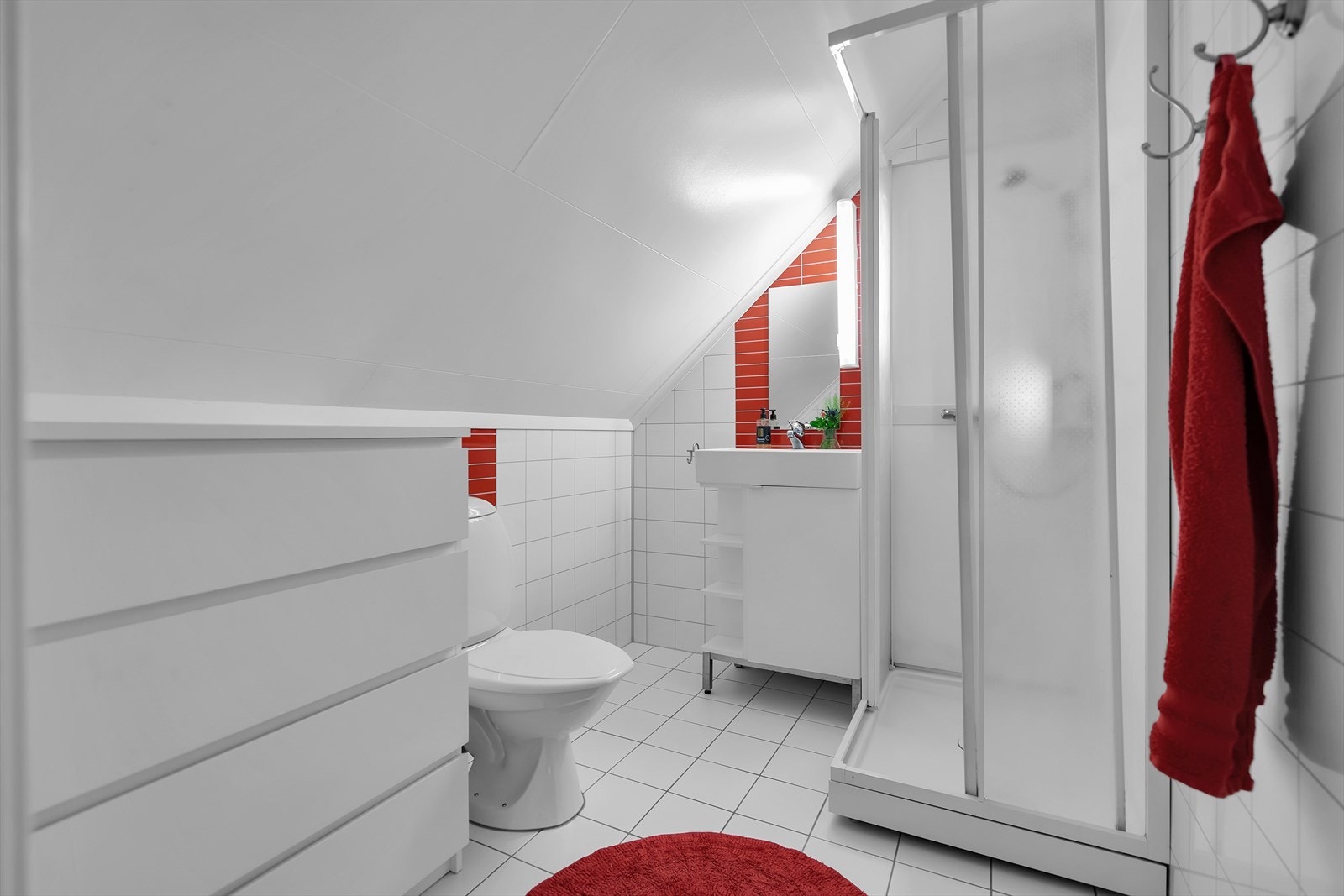 Flislagt bad på loft med dusjkabinett og plass til oppbevaring. Galleribilde