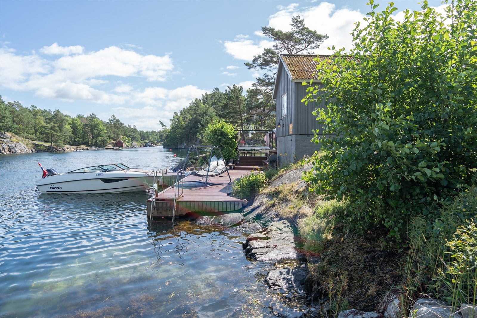 Terskelfjord og brakkvann gjør at det er god badetemperatur. Her er det også badestige. Galleribilde