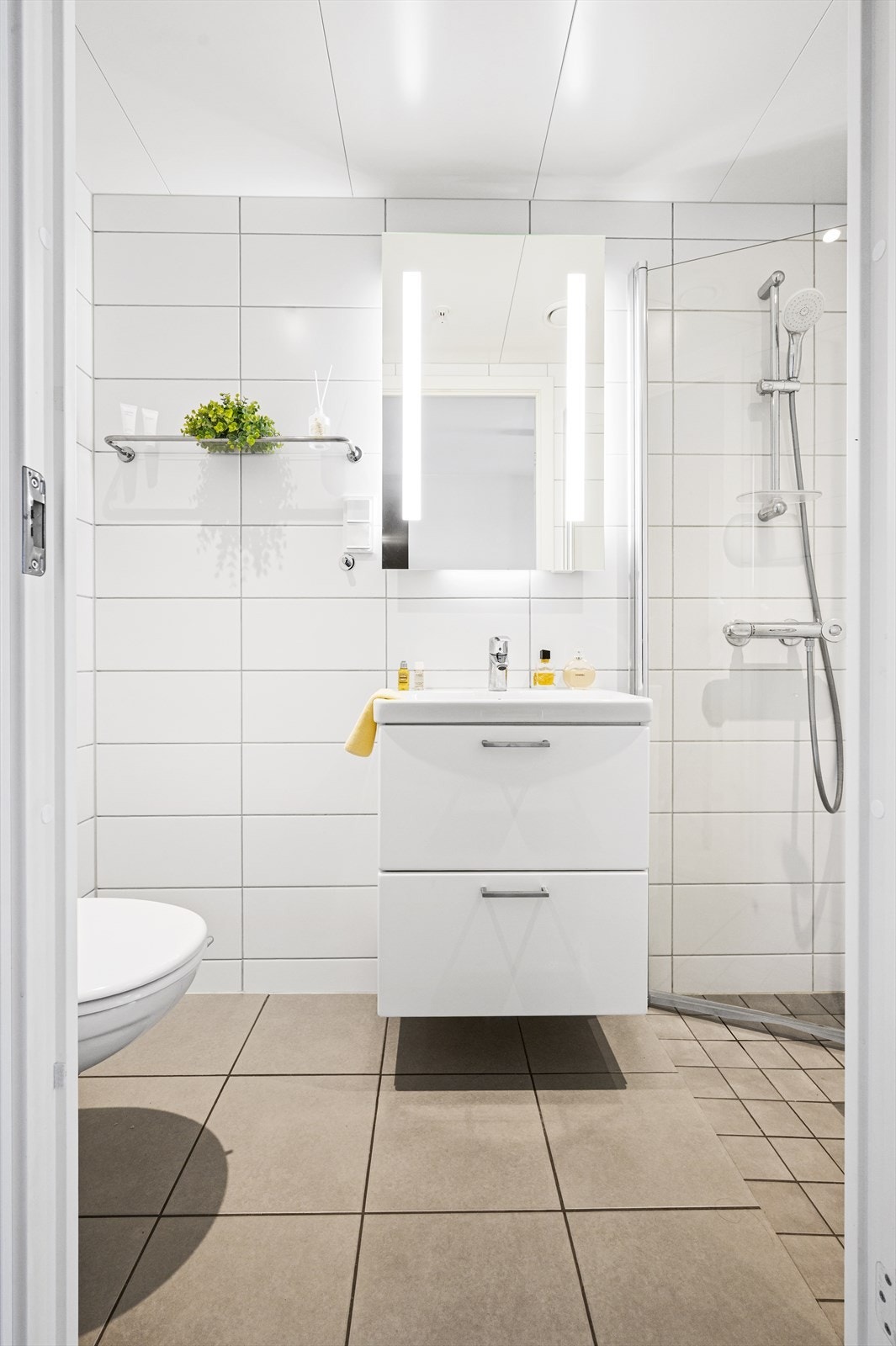 Gjestebadet har flislagte gulv med gulvvarme og flislagte vegger. Himlingen består av lakkerte stålplater med innfelte downlights. Galleribilde