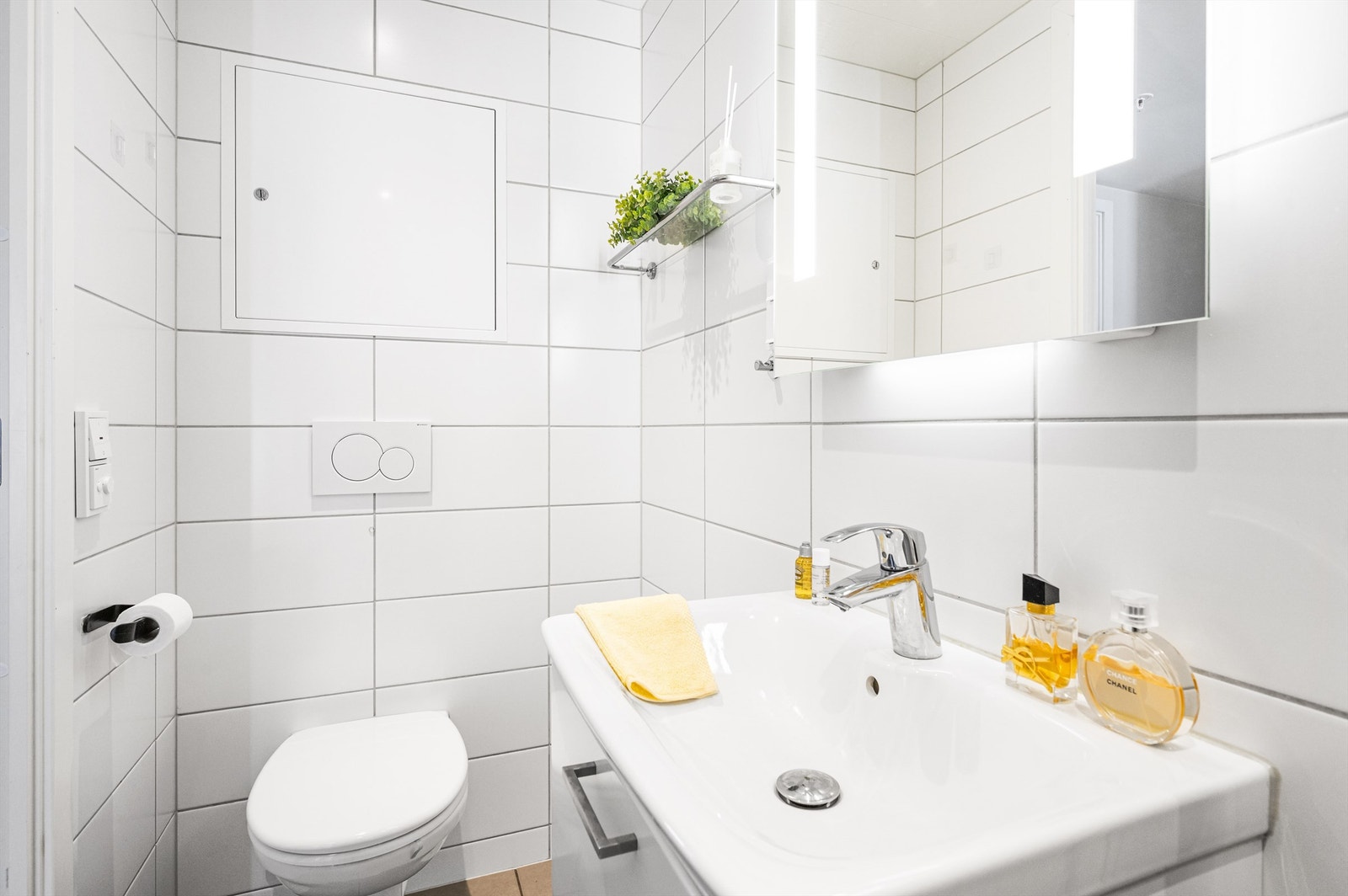 Rommet er innredet med vegghengt klosett, servant nedfelt i praktisk baderomsinnredning, speilskap med lys og dusjhjørne med svingbare glassdører. Det er balansert ventilasjon for et godt inneklima. Galleribilde