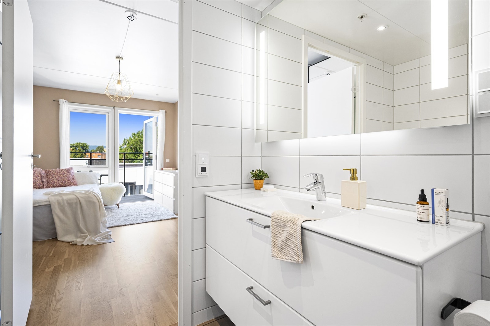 Badet er innredet med vegghengt klosett, servant nedfelt i moderne innredning, speilskap med belysning og dusjhjørne med svingbare glassdører. Galleribilde