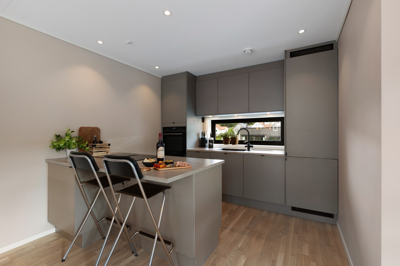 Kjøkkenet har innredning med glatte fronter fra HTH og benkeplate av laminat. Galleribilde