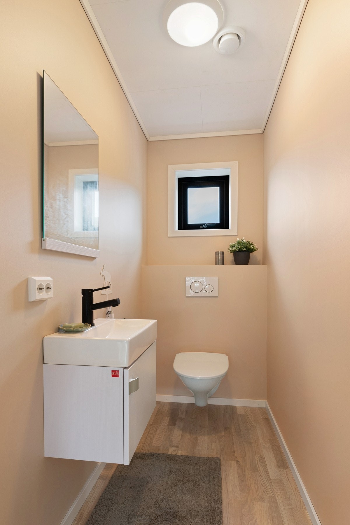 Toalettrom med vask og vegghengt toalett. Galleribilde